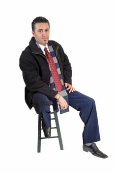 A tall and young businessman sitting on a chair in a black coat for.white background relaxing..