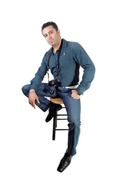 A young handsome man sitting on a chair with his camera around his neck,.for white background..