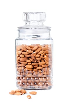 Glass jar with raw almonds isolated on white background