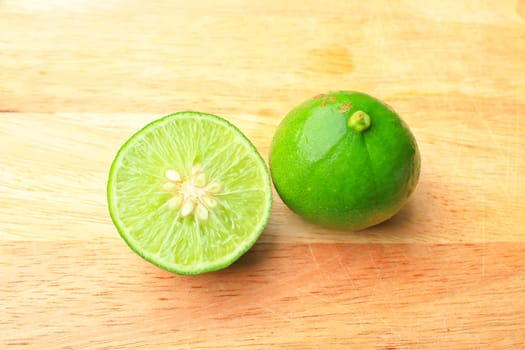Fresh organic cut limes on wooden cutting board