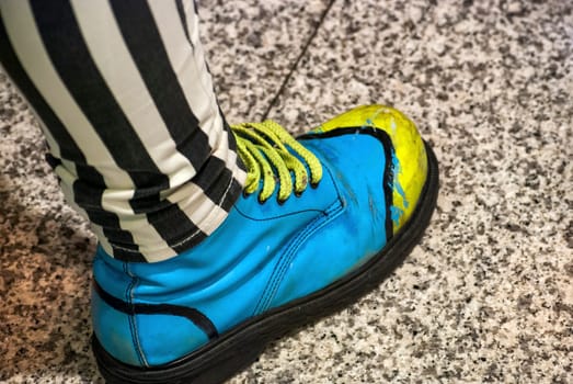 Female leg with colored shoe on granite floor