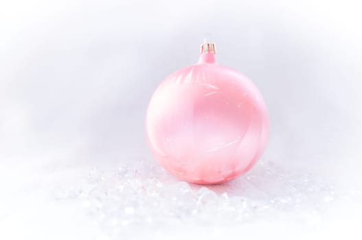 pink Christmas bauble on ice
