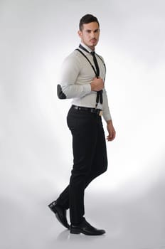 Full body shot of elegant and stylish young man on light background, profile standing