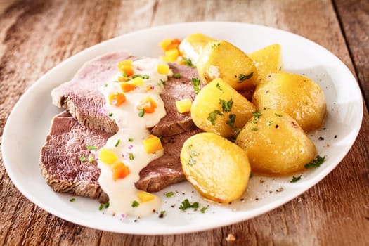 Sliced lean cap of rump served with delicious golden roast potatoes sprinkled with chopped parsley and topped with sour cream or creamy moyonnaise sauce