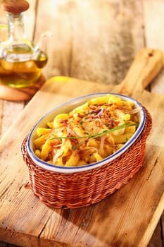 Dish filled with golden deep fried German spatzle, or egg noodle dumplings garnished with fresh chives