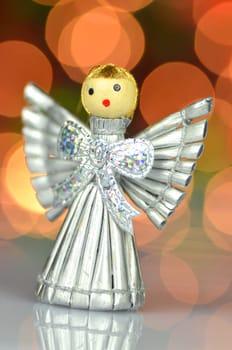 christmas decoration, silver angel made of straw against bokeh background