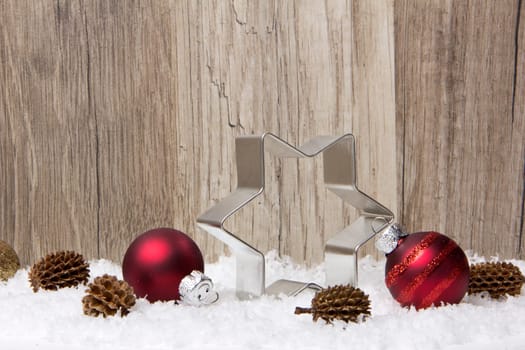 Christmas,decoration with wooden background,snow,Christmas baubles red,gold and pine cones