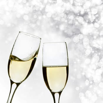 Glasses with champagne against silver holiday lights