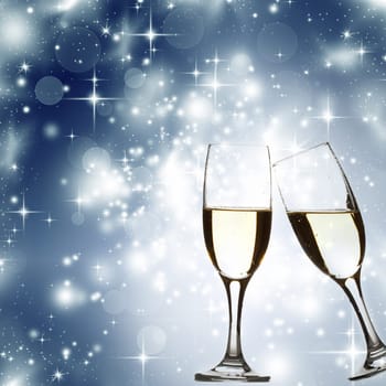 Glasses with champagne against blue holiday lights and stars