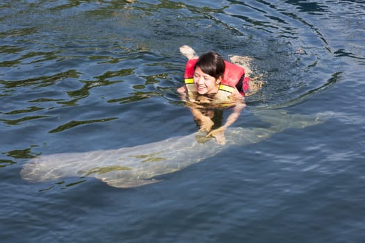 Swimming with dolphin,teenager with fish in the water