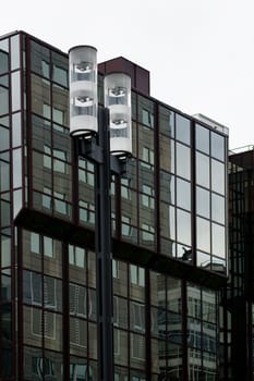 Die abstrakte Reflektion von Straßenlaternen in der Glasfassade eines modernen Hauses.