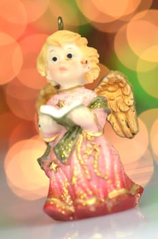 christmas decoration, figure of little angel singing carols against bokeh background
