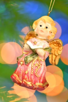christmas decoration, figure of little angel singing carols against bokeh background