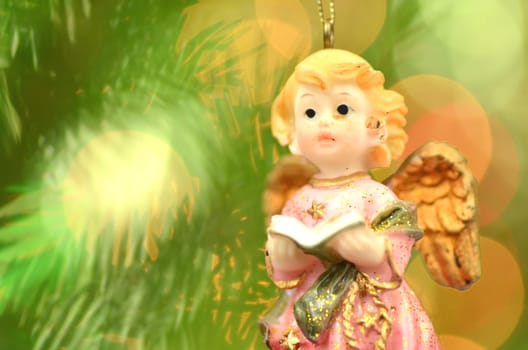christmas decoration, figure of little angel singing carols against bokeh background