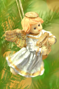 christmas decoration, figure of little angel playing the harp against bokeh background