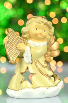christmas decoration, figure of angel playing the harp against bokeh background