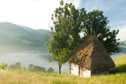 Old cottage in the Carpathian mountains in the sunrise