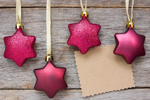 Xmas card on wooden wall with christmas baubles