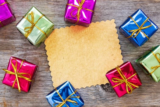 Christmas card on wooden wall with a colorful gifts