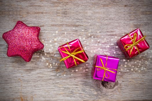 Christmas star and gifts on the wooden background
