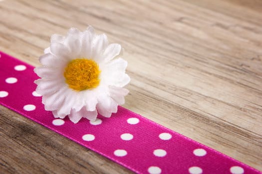 Daisies on ribbon pink with wooden background