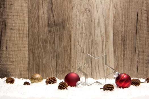 Christmas,decoration with wooden background,snow,Christmas baubles red,gold and pine cones