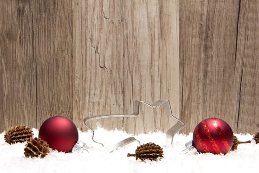 Christmas,decoration with wooden background,snow,Christmas baubles red,gold and pine cones