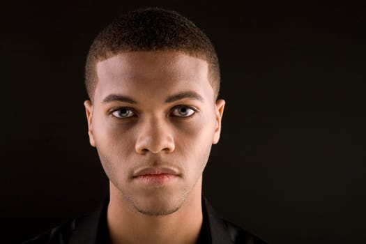 Portrait of a handsome young black man with dark background