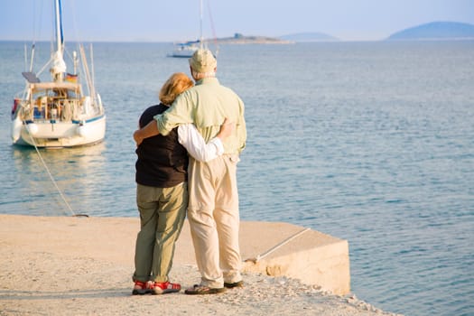 Senior couple is watching sailboats off the coast of Croatia