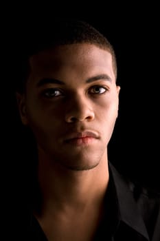 Portrait of a handsome young black man with dark background