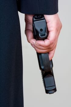 Close up of a the back side of a woman in business suit holding a hand gun