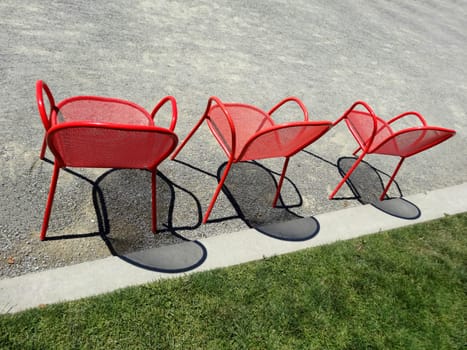 Three empty red chairs in a row from behind
