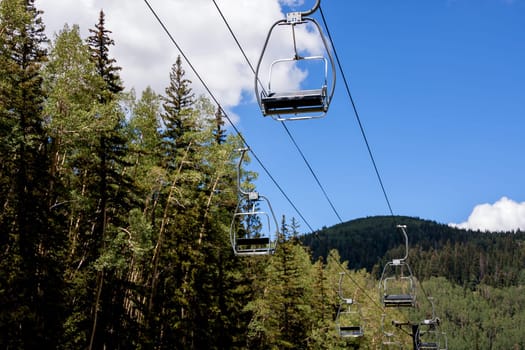 Empty ski lift seats in alpine summer landscape