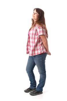 Girl with long dark hair wears a checkered blouse and jeans,stands in front of a white background