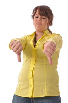 Pretty teenage girl in yellow blouse and jeans poses against a white background. Make 'thumbs down' gesture and look angry into the camera.