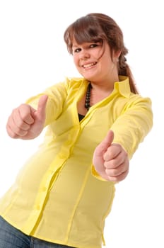 Pretty teenage girl in yellow blouse and jeans poses against a white background. Make 'thumbs up' gesture and laugh.