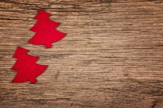Rustic wooden background with two red Christmas trees