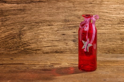 Red glass bottle against a wooden background