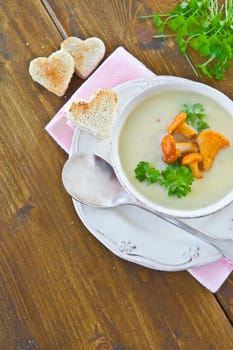 Creamy mushroom soup in cup with fresh chanterelles