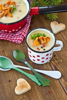 Creamy mushroom soup in cup with fresh chanterelles