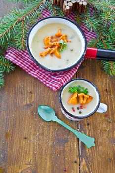 Creamy mushroom soup in cup with fresh chanterelles