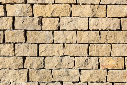 Detail of a outdoors wall made with stone stacked.