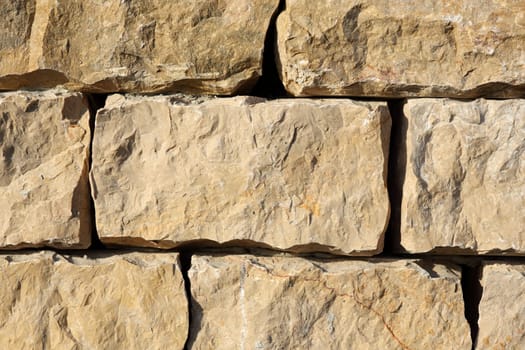 Detail of a outdoors wall made with stone stacked.