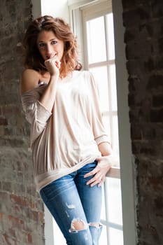 Attractive young woman standing by the window