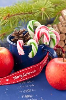 Colorful candy canes in a small enamel cup