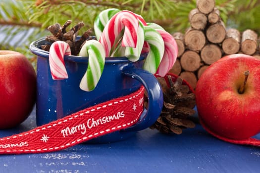 Colorful candy canes in a small enamel cup
