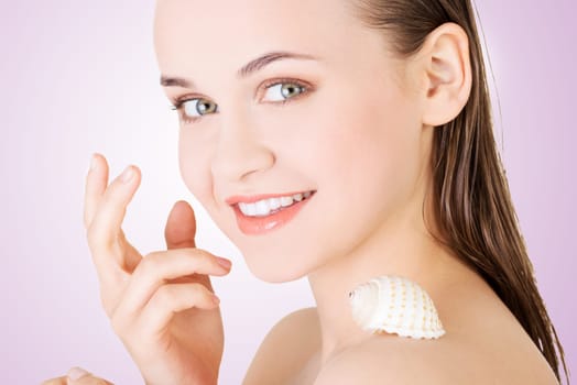 beautiful face of spa woman with healthy clean skin and sea shell.