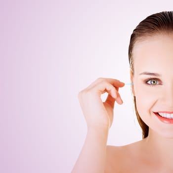 woman face closeup while cleaning up an ear with a swab