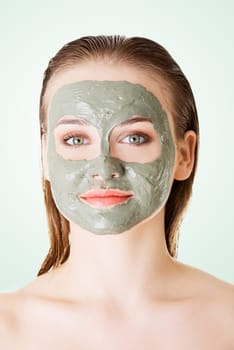 beautiful woman with green clay facial mask