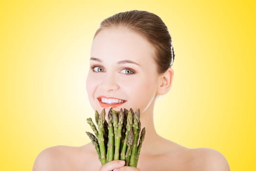 beautiful fit woman with asparagus,over yellow
